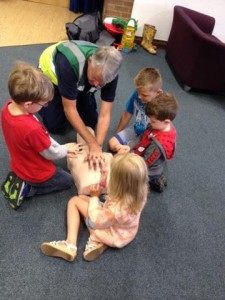 children learning CPR techniques from  1st responders