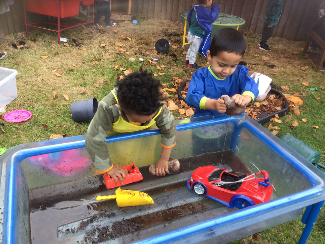 Children playing with mud and toy cars