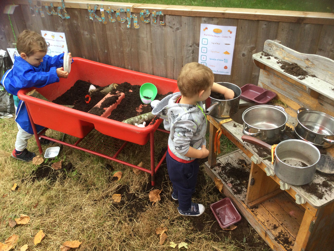 Child playing with saucepans and mud