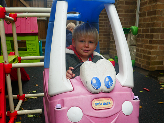 Child playing with car outdoors 