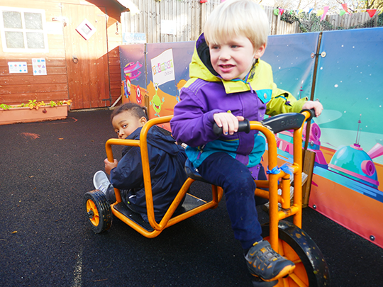 Children playing outdoors on tricycle