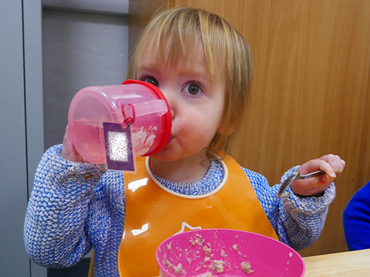 A little girl enjoying having a drink