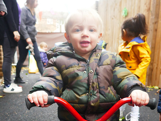 Child playing outdoors on a tricycle