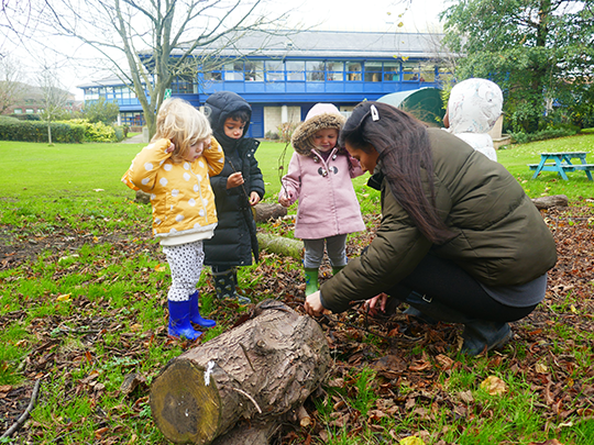 Children with nursery staff outdoors